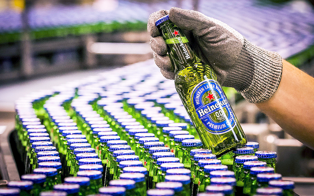 Flaskor med alkoholfri öl i rader på produktionsband