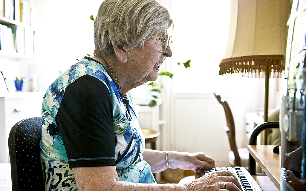 Äldere kvinna framför dataskärm