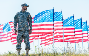 Soldat framför rad av amerikanska flaggor