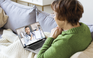 Kvinna konverserar med läkare via bärbar dator