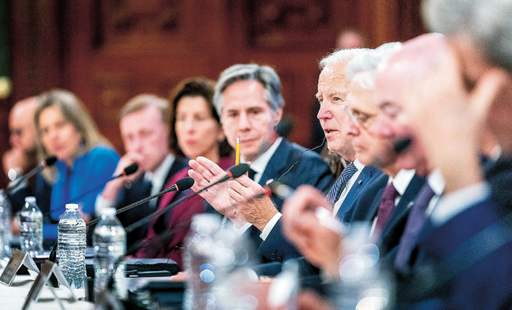 USAs president och utrikesminister sitter utmed ett långbord tillsammans med andra politiska ledare. Joe Biden förklarar något för åskådarna.