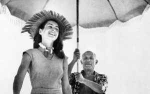 Picasso med sin dåvarande partner, Françoise Gilot på en strand. Picasso håller ett parasoll över huvudet på Françoise Gilot.