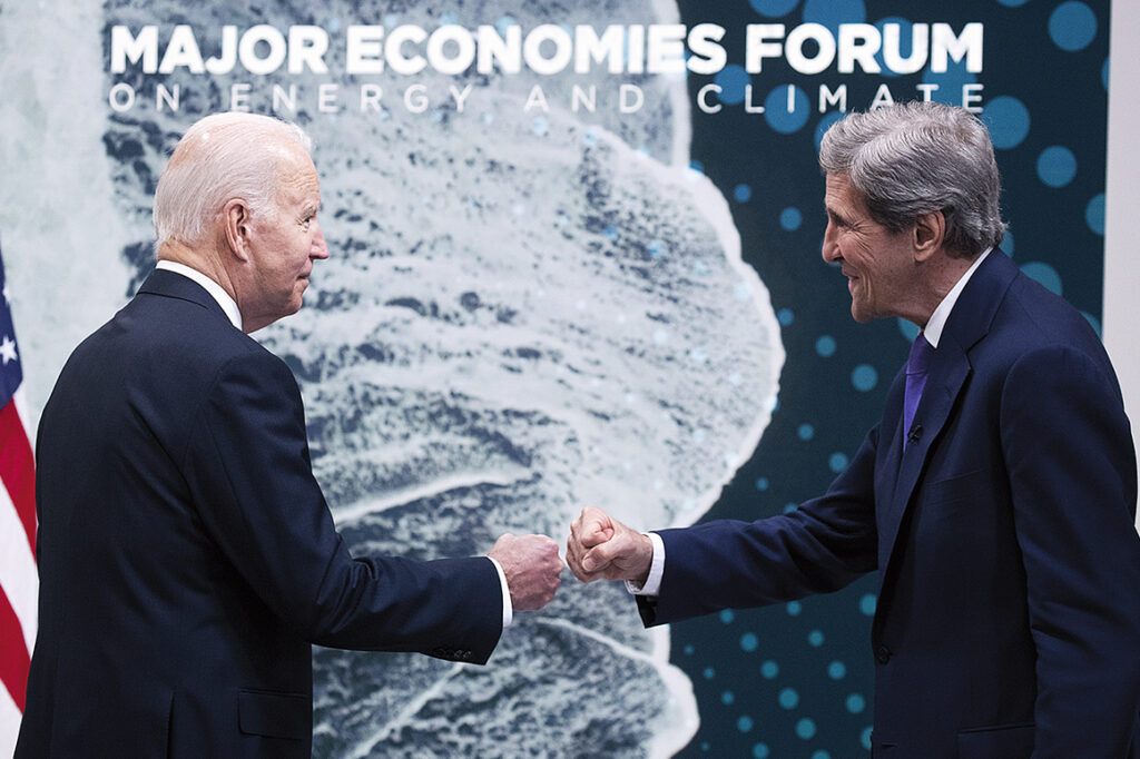 President Joe Biden hälsar på USA:s särskilda sändebud för klimatfrågor, John Kerry, på ett klimattoppmöte.